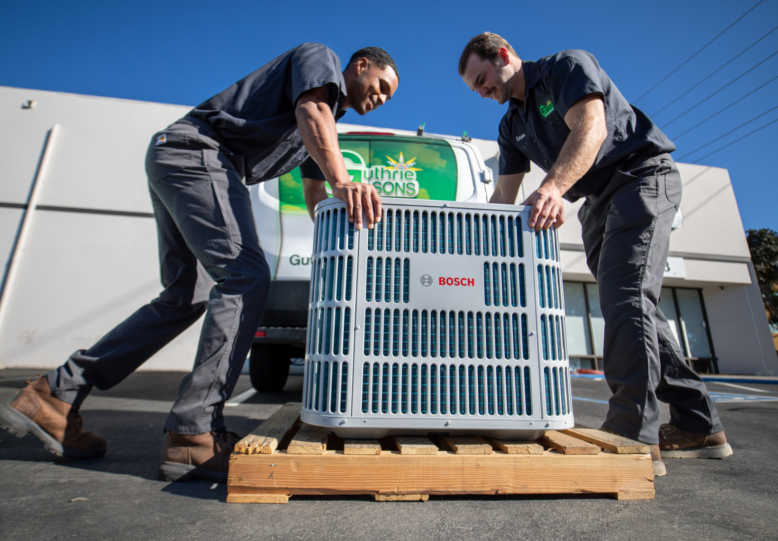 guthrie technicians unloading air conditioning condenser